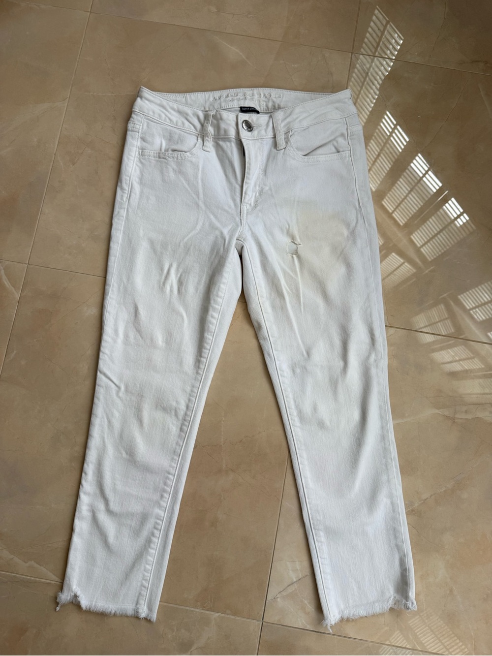 white cropped jeans with a raw frayed hem